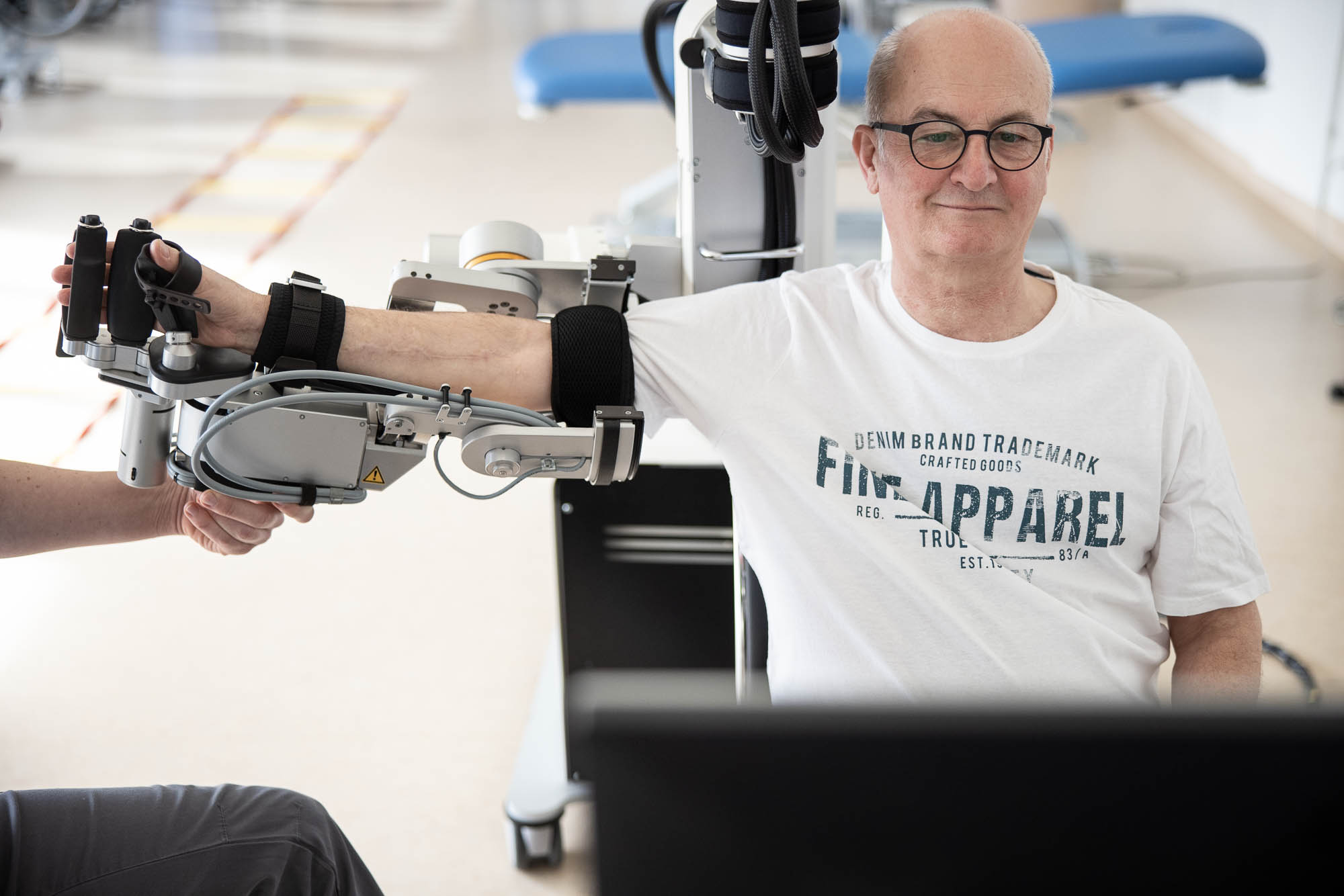 Patient beim Training mit dem Armroboter